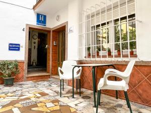 Beatriz Charming Hostal في توريمولينوس: طاولة وكراسي أمام المبنى