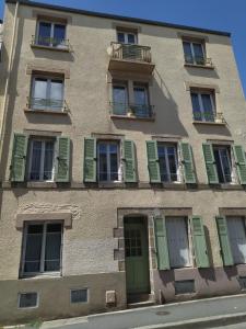 um edifício alto com portas e janelas verdes em Appartement Brest avec belles prestations em Brest