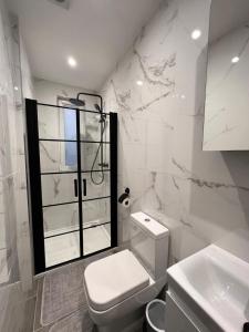 a white bathroom with a toilet and a window at Star London Finchley Lane 3-Bed Retreat in Hendon