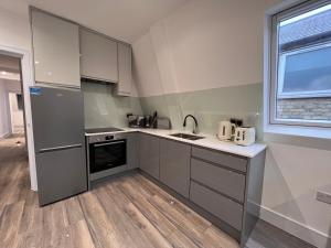 a kitchen with stainless steel appliances and a window at Star London Finchley Lane 3-Bed Retreat in Hendon