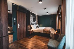a hotel room with a bed and two chairs at Mediterraneo Luxury Room Esztergom in Esztergom