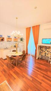 un soggiorno con tavolo e sedie e una cucina di Napoli Tree - Lungomare a Napoli