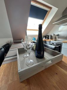 a bottle of wine and two glasses on a counter in a kitchen at Epernevasion in Épernay