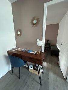 a wooden desk with a blue chair and a mirror at Epernevasion in Épernay