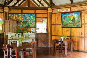 a dining room with tables and chairs and a painting on the wall at Cabañas el Bosque in Turrialba