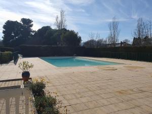 a swimming pool in a yard with a brick patio at L'OREE DU GOLF in Mandelieu-la-Napoule