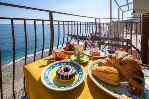 a table with two plates of pastries and bread on it at Loft Panorama di Naxos in Giardini Naxos