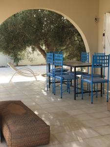 una mesa y sillas en un patio con un árbol en Dar A'Mina, en Zarzis