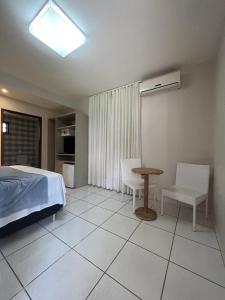 a bedroom with a bed and a table and chairs at Pousada Canto do Sabiá - Pirenópolis in Pirenópolis