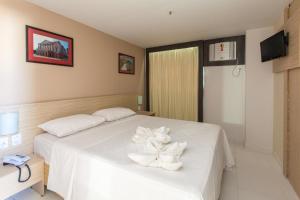 a bedroom with a white bed with white towels on it at Rede Andrade Hangar in Belém