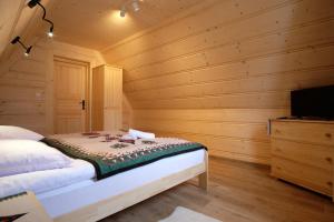 - une chambre avec un lit dans une pièce en bois dans l'établissement Domeczek Góralski Zakopane, à Zakopane
