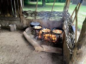 een groep van drie delen van voedsel koken op een grill bij Uniek overnachten in de prehistorie in Lelystad