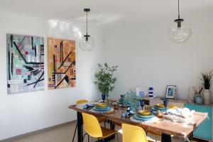 une salle à manger avec une table en bois et des chaises jaunes dans l'établissement Home of the Sun - Luminoso adosado con vistas al mar y a 2 km de la playa, à Vélez-Málaga