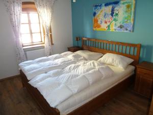 a large bed with white sheets in a room with a window at Apartment Bohinjčan in Bohinj