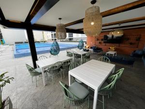 a patio with tables and chairs and a swimming pool at Departamento inteligente de lujo en Solares in Guadalajara