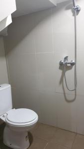 a bathroom with a toilet and a shower at Adinda Syariah C-10 Bukit Gardenia Resort in Tarogong