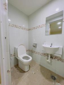 a bathroom with a toilet and a sink at Noor Hotel Kangar in Kangar