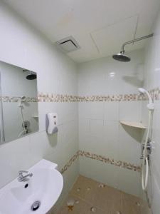 a white bathroom with a sink and a mirror at Noor Hotel Kangar in Kangar