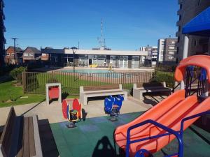 a playground with a slide and a swimming pool at Hermoso departamento completamente equipado in Osorno
