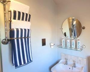 La salle de bains est pourvue d'un lavabo, d'un miroir et d'un porte-serviettes. dans l'établissement Well Cottage Country Accommodation, à Brockley Green