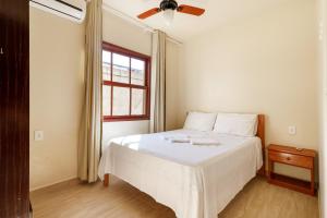 a bedroom with a white bed and a window at Pousada Residencial Bambus in Florianópolis