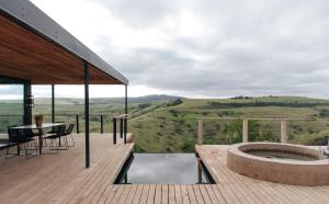 a deck with a hot tub and a table at Gwahumbe Game & Spa in Mid Illovo