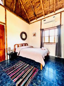 a bedroom with a bed and a rug on the floor at Surfside BEACH FRONT CABANAS in Montañita
