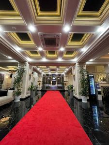 een grote lobby met een rode loper en een rode tapijt bij East Star Hotel in Samarkand