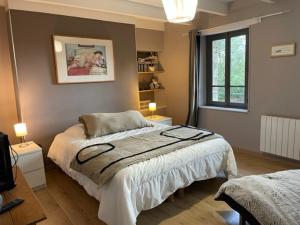 una camera da letto con un letto, due lampade e una finestra di Gîte Est de la pointe d'Agon 4 convives a Agon Coutainville