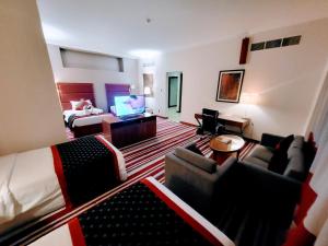 una camera d'albergo con soggiorno dotato di letto e TV di Wonder Palace Hotel Qatar a Doha