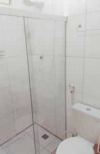 een badkamer met een glazen douche en een toilet bij Casa Arembepe in Camaçari