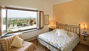 a bedroom with a bed and a large window at B&B I Coppi in San Gimignano