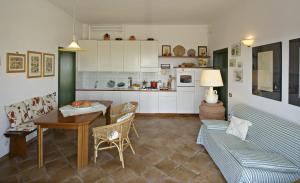 a kitchen and a living room with a couch and a table at B&B I Coppi in San Gimignano