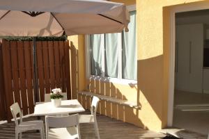 a table and chairs with an umbrella on a patio at Residence Finale Bike and Beach in Finale Ligure