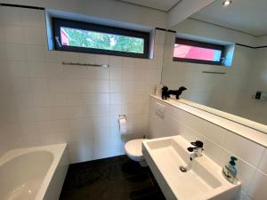 a bathroom with a sink and a toilet and a window at BALTHASAR RESS Guesthouse am Rebhang im Rheingau in Oestrich-Winkel