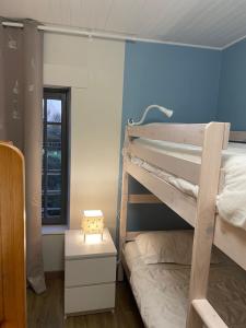 - une chambre avec des lits superposés et un mur bleu dans l'établissement Gite Ouest de la pointe d'Agon, à Agon-Coutainville