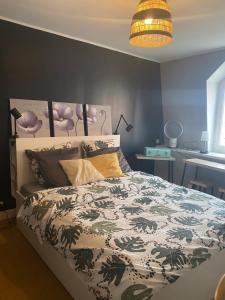 een slaapkamer met een bed met een groen en wit dekbed bij Chambre Archi in Écourt-Saint-Quentin