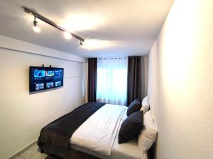 - une chambre avec un lit et une télévision murale dans l'établissement Klein aber fein 2, à Düren