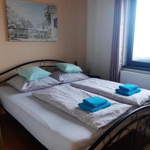 1 dormitorio con 2 camas y toallas azules. en Apartmán u Javorů, en Varnsdorf