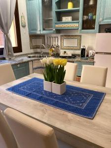 a kitchen with a table with flowers on it at La Marina Apartment with Pool in Olbia