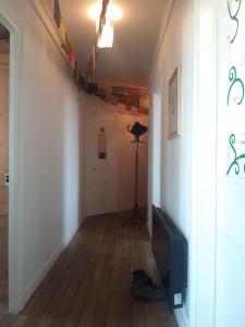 a hallway with a room with a television and a door at Vue sur les toits de Paris, tour Effeil, centre malakoff, chambre chez l'habitant, sans ascenseur, à deux pas de Paris in Malakoff