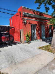 un bâtiment rouge avec une voiture garée devant lui dans l'établissement Casa Victoria, à Colonia del Sacramento