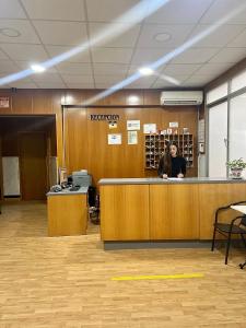 a woman sitting at a reception counter in an office at Hospederia del Pilar in Valencia