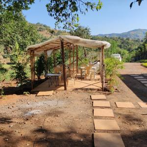 a gazebo with a table and chairs under it at Exotic Stay - a unique experience in Pune