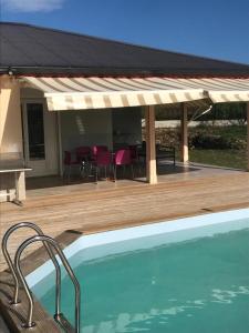 a patio with a pool and a deck with a pavilion at villa domaine des palétuviers in Le Moule