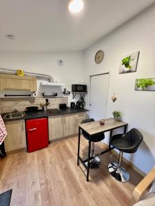 a kitchen with a desk and a table in a room at Les gîtes de la bergerie in Meximieux