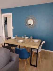 a dining room with a table and a blue wall at Appartement avec vue mer in Vaux-sur-Mer