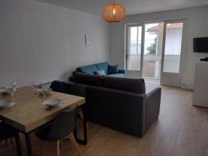 a living room with a couch and a table at Appartement avec vue mer in Vaux-sur-Mer