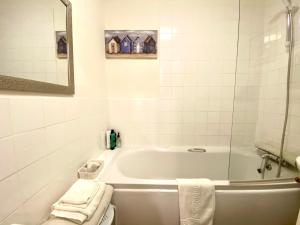Baño blanco con bañera y lavamanos en Grosvenor Apartments in Bath - Great for Families, Groups, Couples, 80 sq m, Parking en Bath