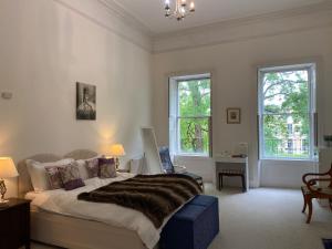 a bedroom with a large bed and two windows at Grosvenor Apartments in Bath - Great for Families, Groups, Couples, 80 sq m, Parking in Bath